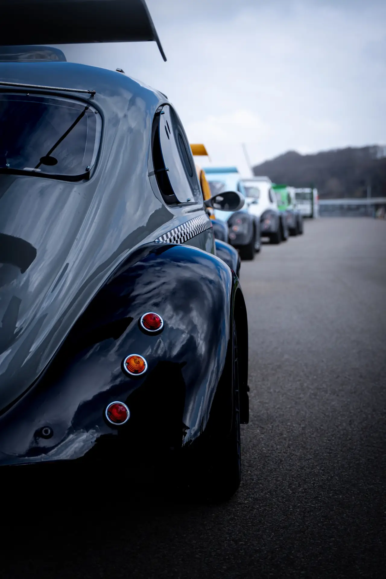 Plusieurs voitures alignées sur une piste, dont une en premier plan.